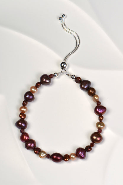 real pearl bracelet with berry and chocolate coloured pearls and garnets. It has an adjustable silver slider clasp. One of a kind. 