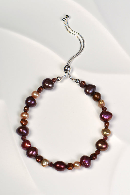 real pearl bracelet with berry and chocolate coloured pearls and garnets. It has an adjustable silver slider clasp. One of a kind. 