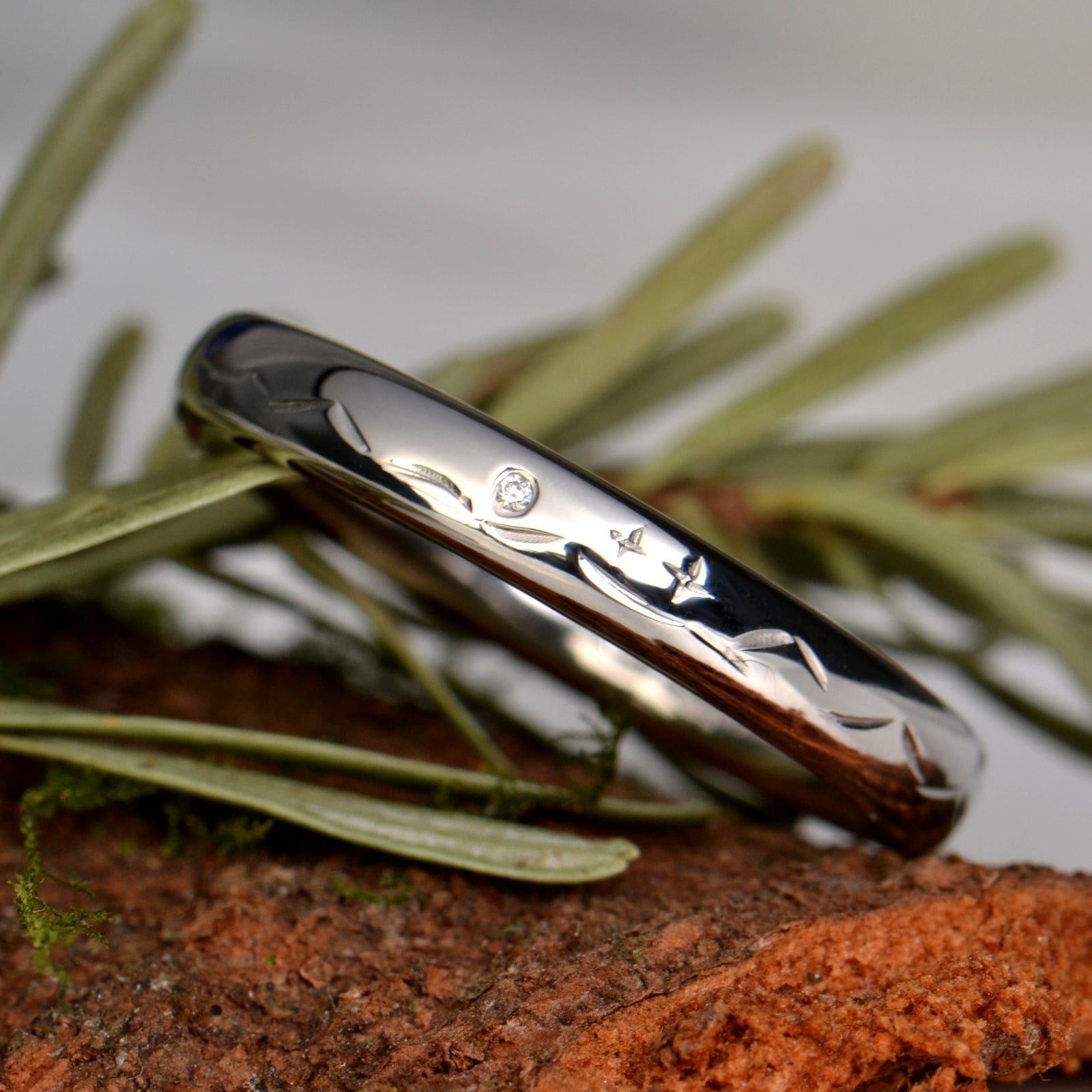 narrow platinum wedding ring with a mountain design, two stars and a diamond