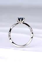 side view of the platinum and diamond heart cut Alexandrite colour change ring showing the sculptural design of the tiny flames that rise up to hold the gemstone