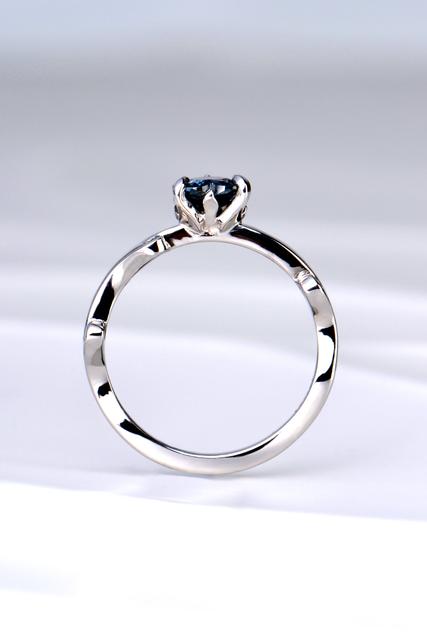 side view of the platinum and diamond heart cut Alexandrite colour change ring showing the sculptural design of the tiny flames that rise up to hold the gemstone
