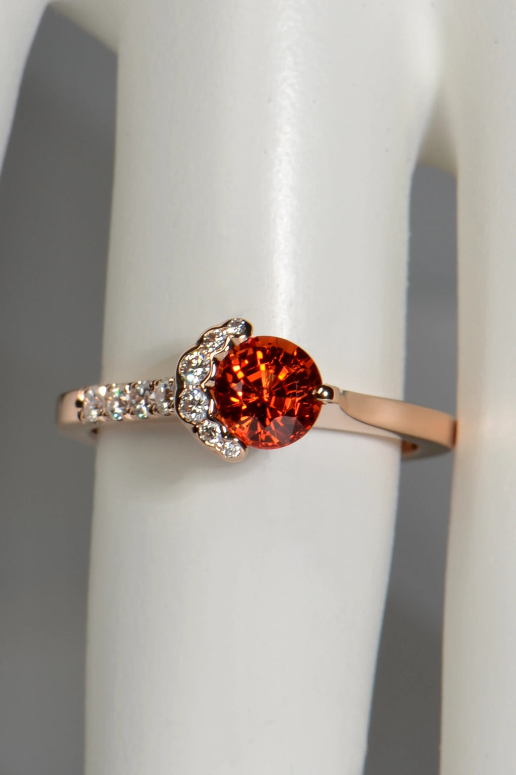 Orange sapphire Fairypools ring in 18ct rose gold, seen from above on a display finger.