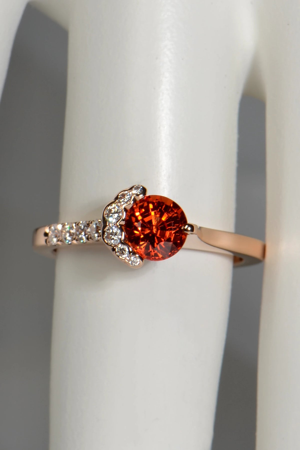 Orange sapphire Fairypools ring in 18ct rose gold, seen from above on a display finger.