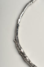 close up details of silver bangle that looks like a twig, a nature inspired design by Jorge Revilla