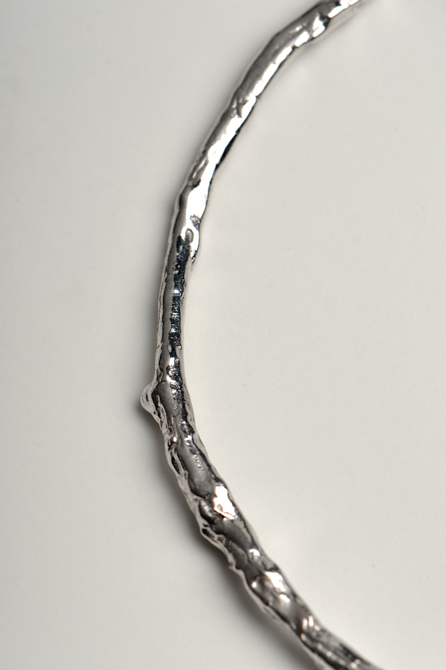 close up details of silver bangle that looks like a twig, a nature inspired design by Jorge Revilla