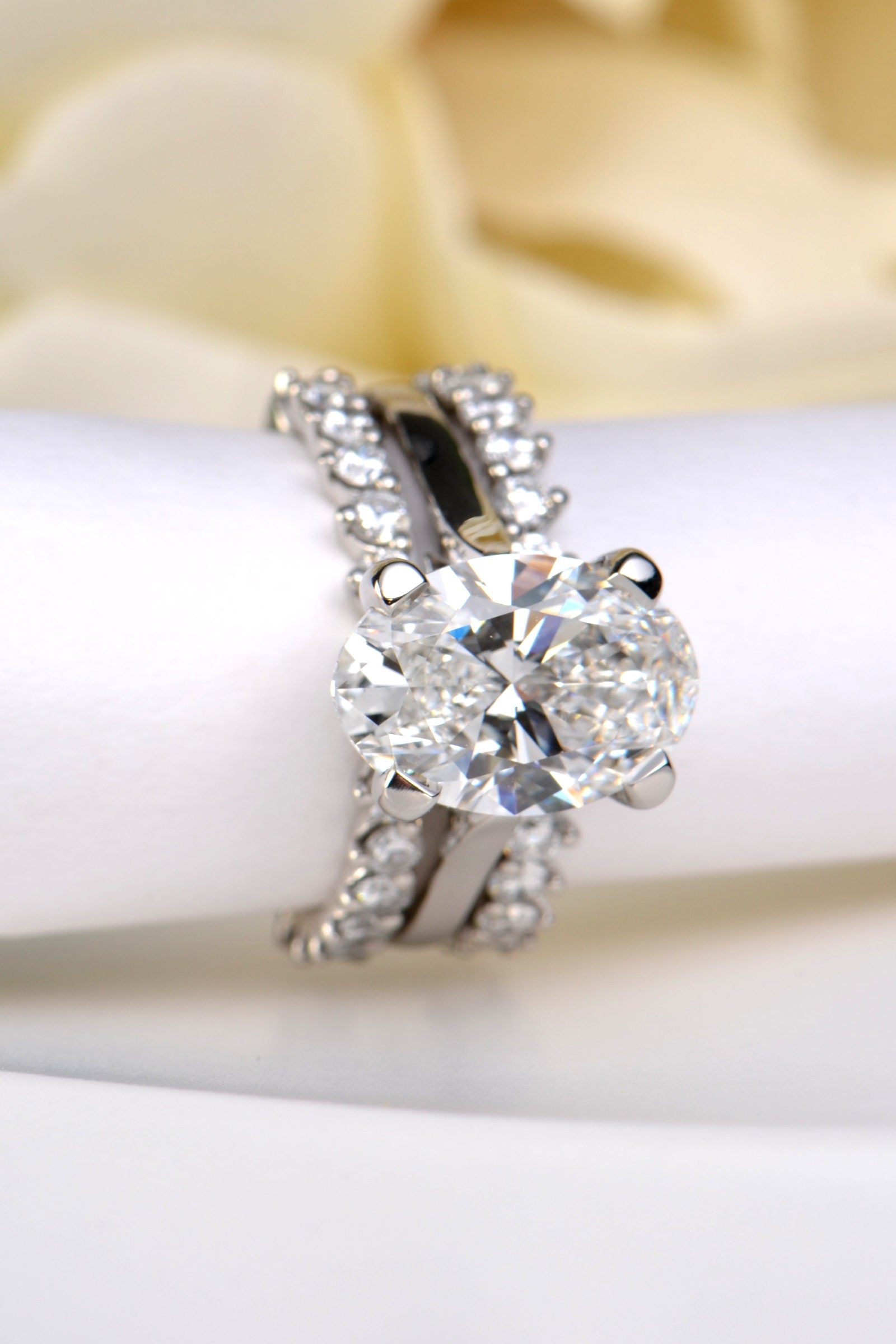 two diamond guard rings, one on either side of an oval cut diamond solitaire ring - Christine Sadler