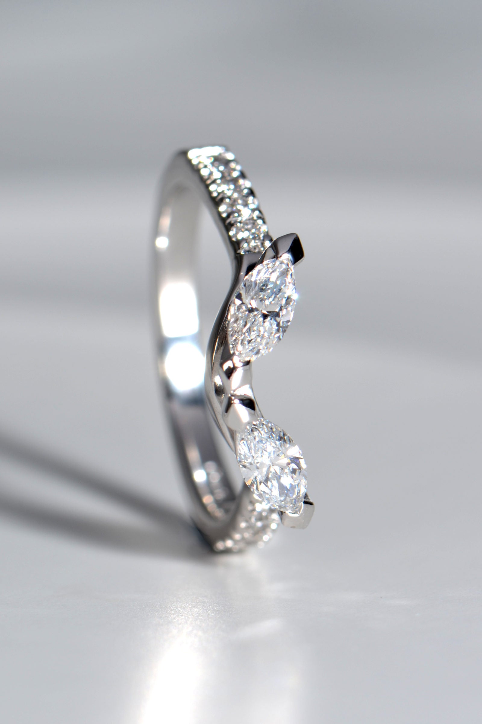 Platinum one-of-a-kind ring commission with two marquise diamonds and small round diamond accents for a unique bridal set