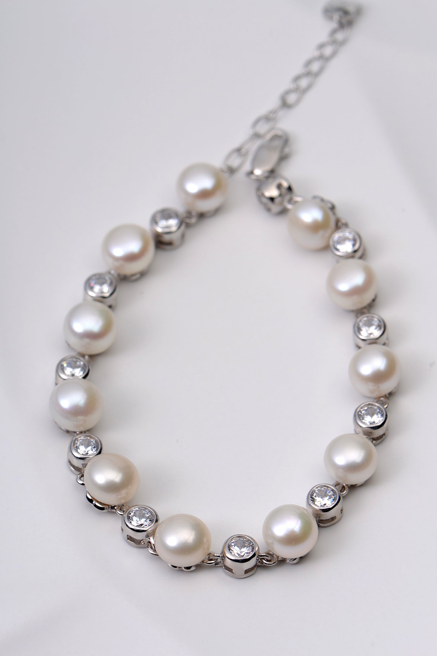 silver pearl bracelet with alternating round sparkly cubic zirconias and adjustable chain at back so it can be altered to fit different wrist sizes