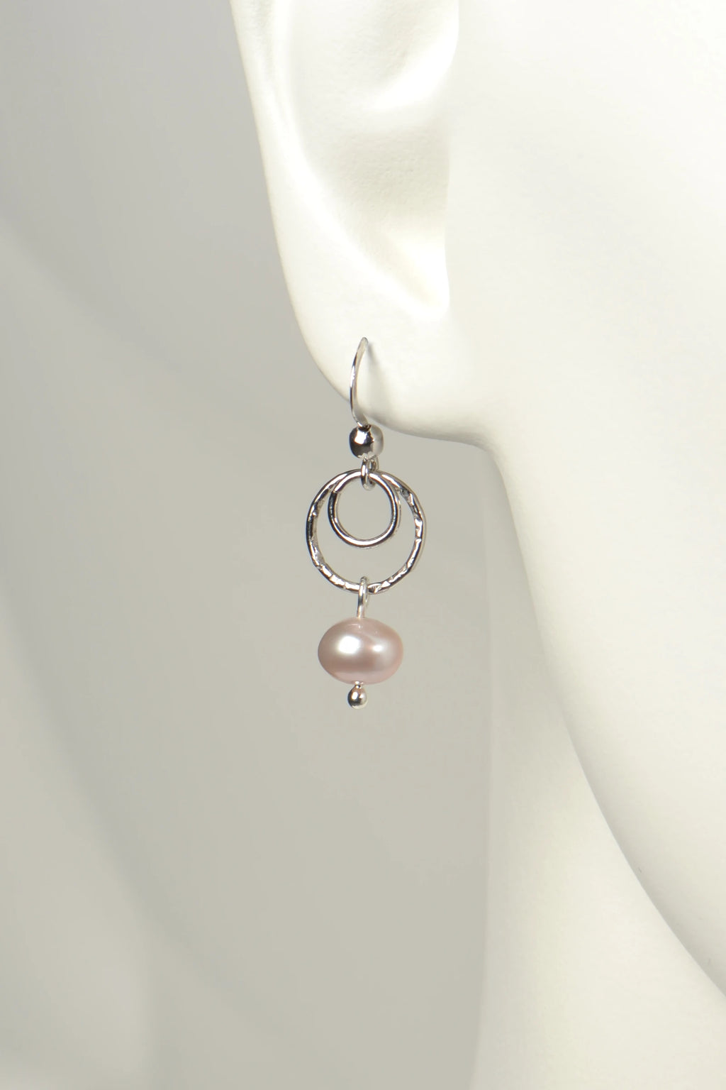 Sterling silver drop earring with a pink cultured pearl on a mannequin ear.