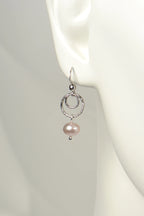 Sterling silver drop earring with a pink cultured pearl on a mannequin ear.