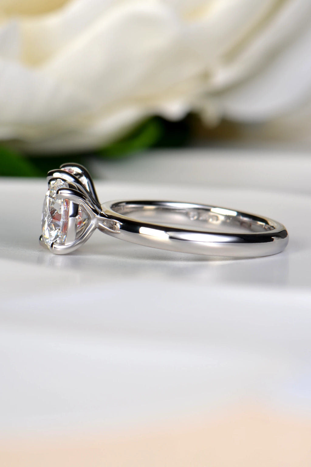 Side profile view of a platinum Moi et Toi engagement ring showing the structural prongs of the 1.58 carat D-color round brilliant cut white lab diamond, by Christine Sadler.