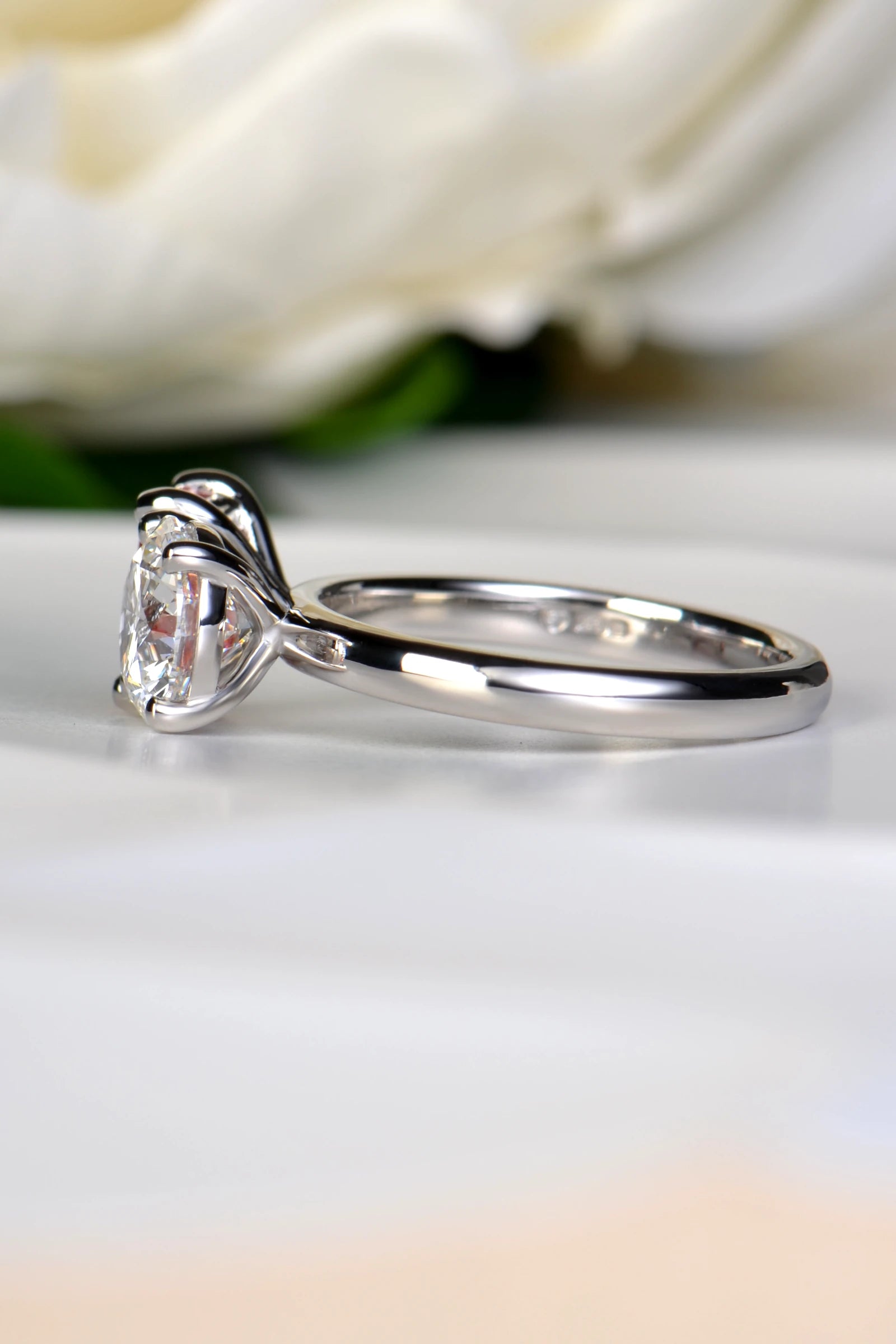 Side profile view of a platinum Moi et Toi engagement ring showing the structural prongs of the 1.58 carat D-color round brilliant cut white lab diamond, by Christine Sadler.