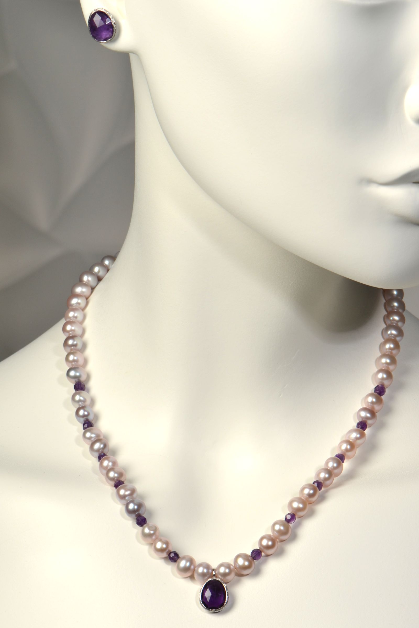 Pink cultured pearl necklace with amethysts on a mannequin with matching amethyst stud earrings
