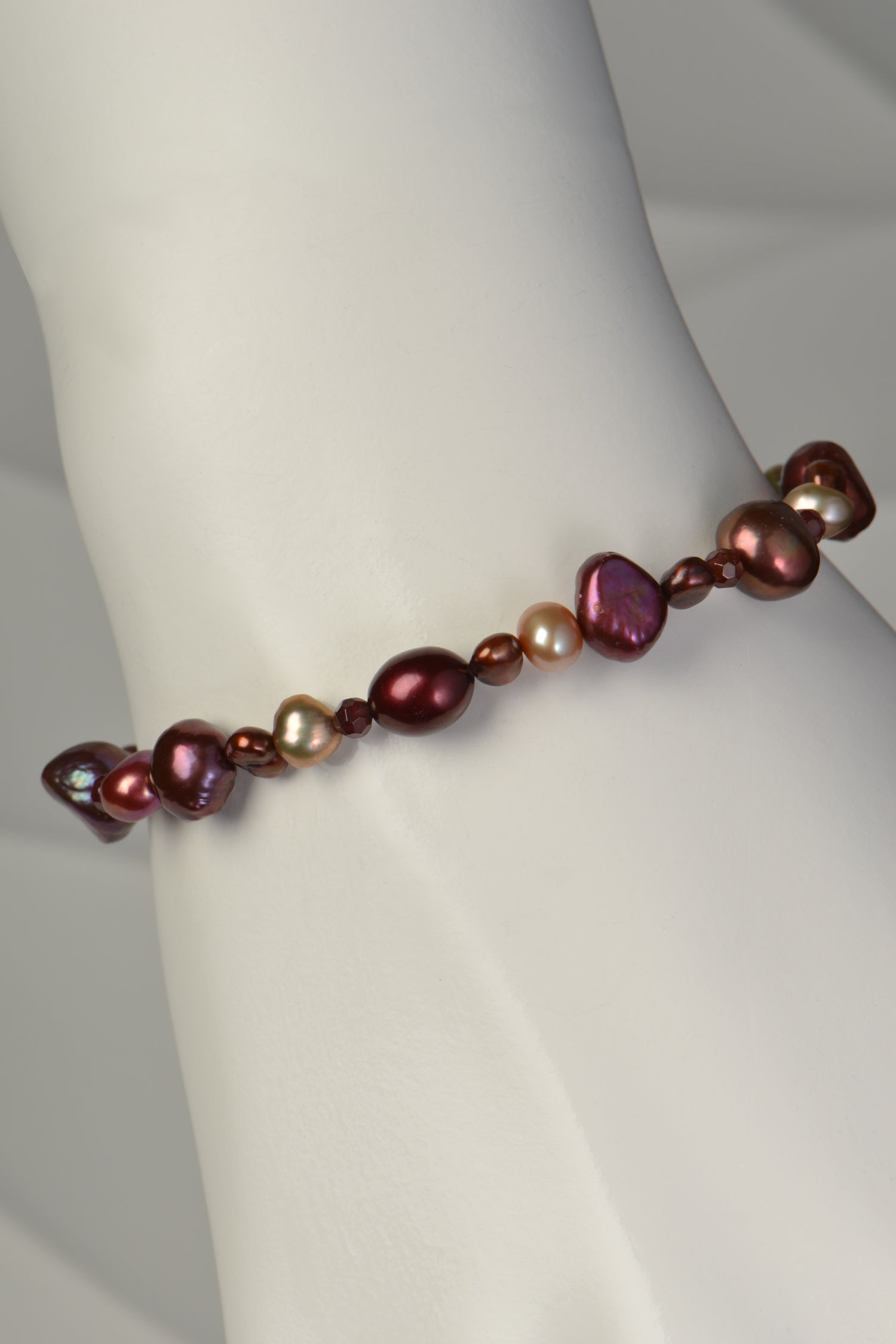 real pearl bracelet in warm autumnal tones of brown red, pink and golden pearls.