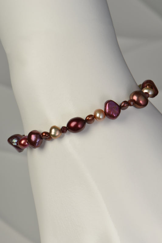 real pearl bracelet in warm autumnal tones of brown red, pink and golden pearls.