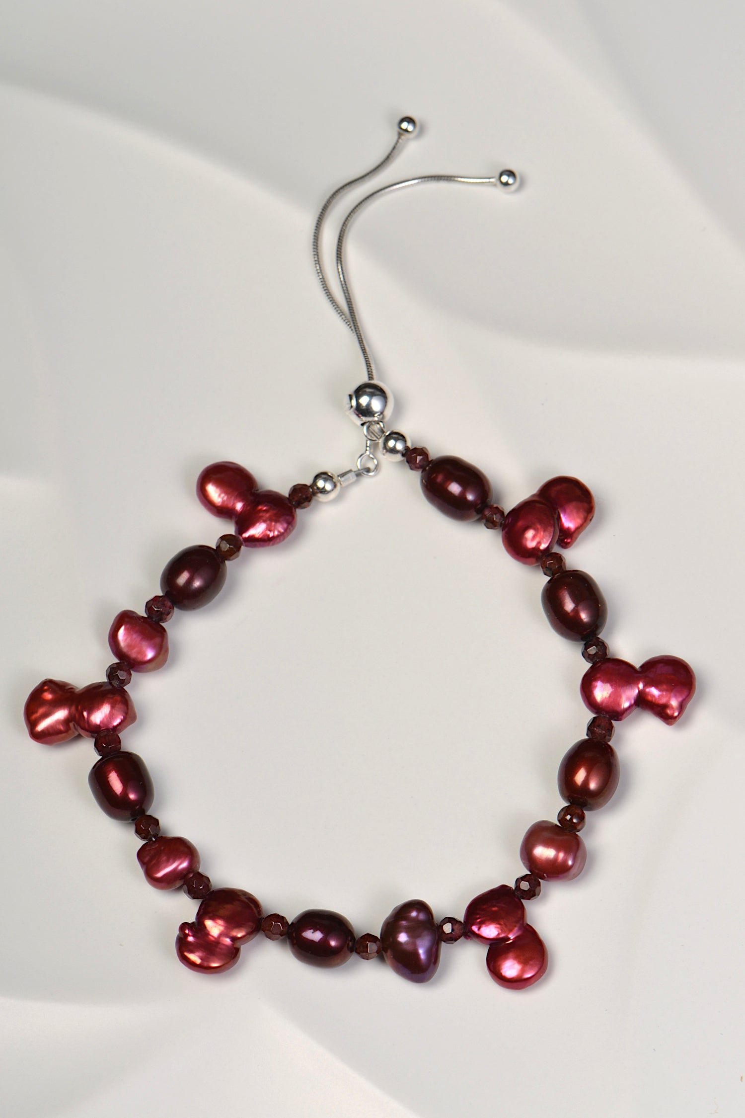 unique red pearl bracelet with six pearls which are formed in the shape of the number 8