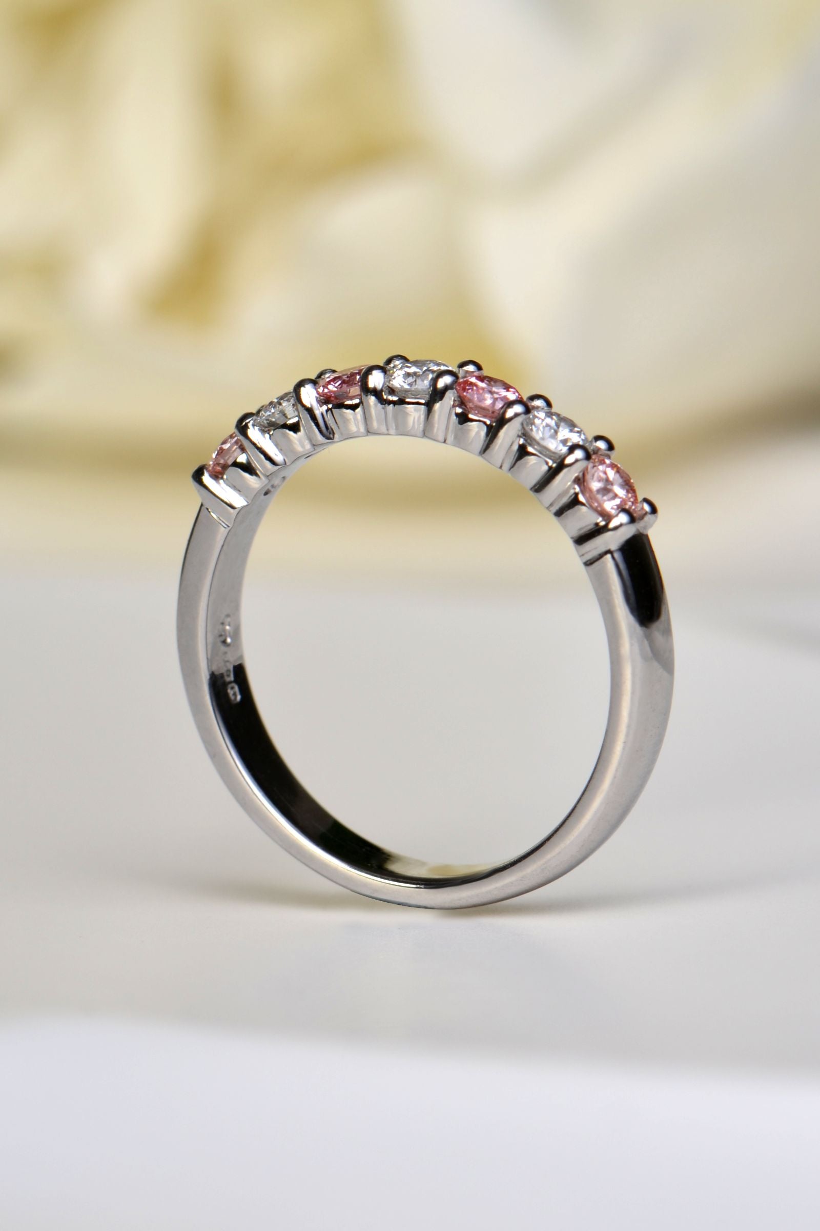 Close-up angled view highlighting the alternating pink and white lab diamonds in platinum
