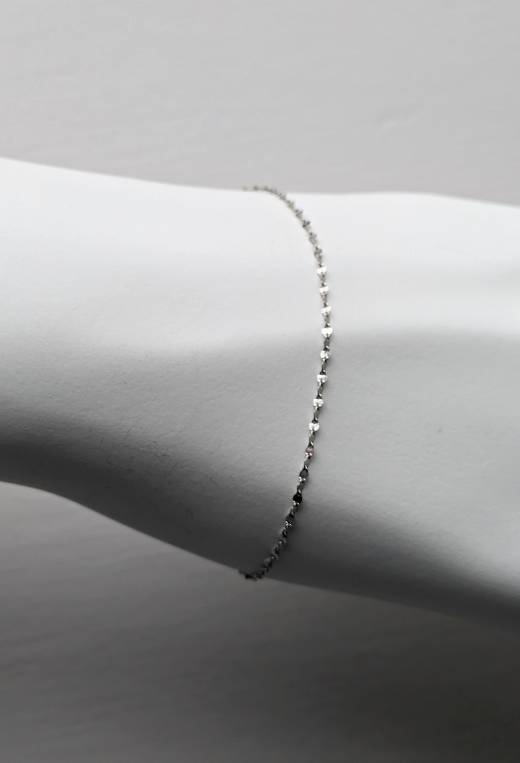 delicate platinum bracelet that sparkles shown on a white mannequin wrist