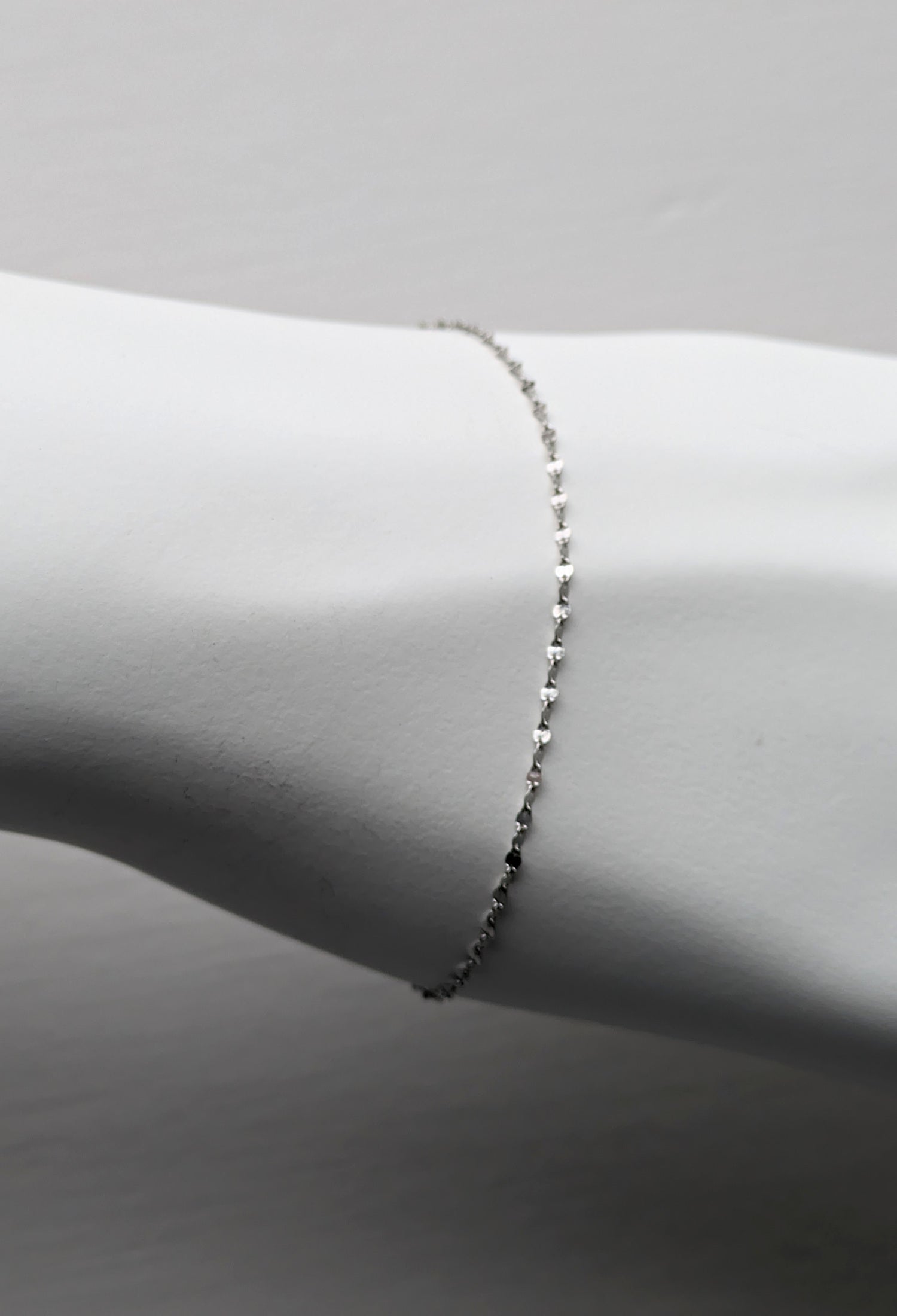 delicate platinum bracelet that sparkles shown on a white mannequin wrist
