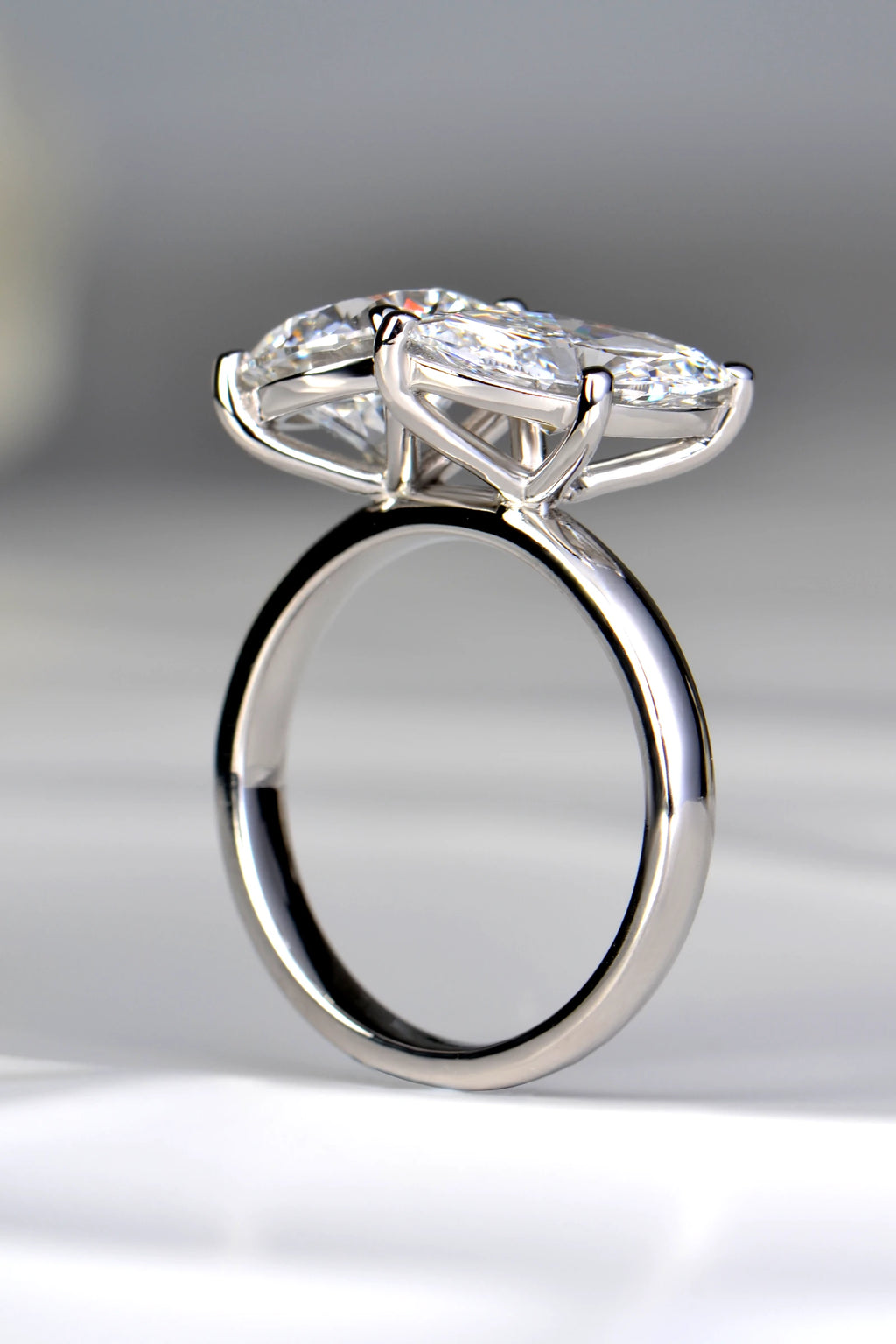 Three-quarter perspective of a handcrafted two-stone lab diamond ring showcasing the continuous uniform depth of the platinum shank by Christine Sadler