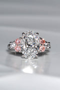 Rosé Spark platinum 950 oval lab diamond ring viewed from above, featuring a 3ct central white lab diamond and six brilliant-cut side stones with pink lab diamond accents.