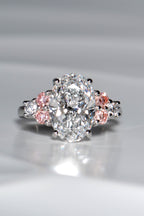 Rosé Spark platinum 950 oval lab diamond ring viewed from above, featuring a 3ct central white lab diamond and six brilliant-cut side stones with pink lab diamond accents.