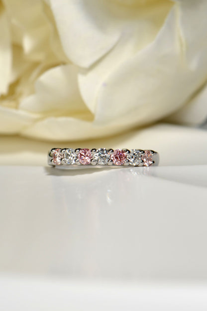 Face-on view of platinum seven-stone ring with four pink and three white lab diamonds
