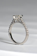 view of side of a pearl cut diamond engagement ring in platinum that has diamonds in the shoulders