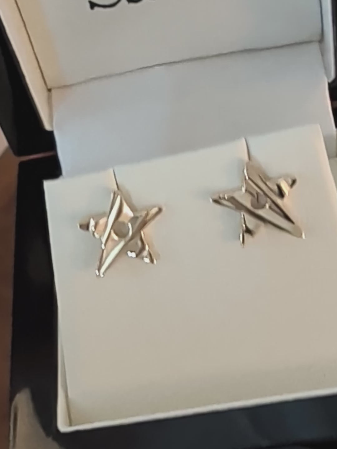 a pair of handmade 9ct gold star stud earrings with groved lines to make the stars look as if they have movement on the surface.
