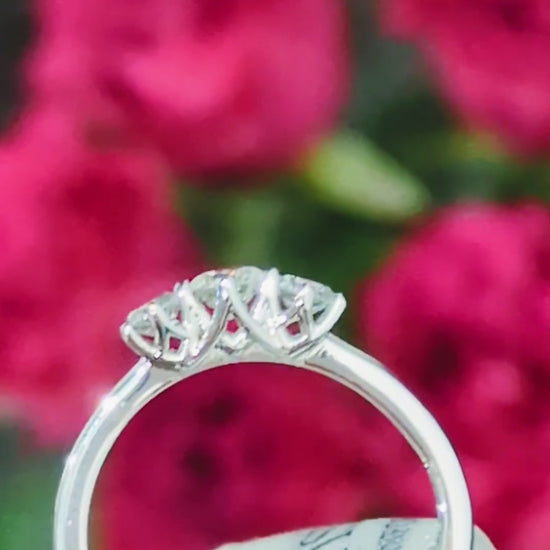 Platinum three stone cathedral diamond engagement ring with vaulted criss-cross claw setting