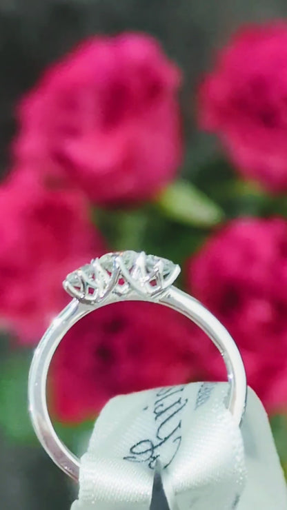 Platinum three stone cathedral diamond engagement ring with vaulted criss-cross claw setting