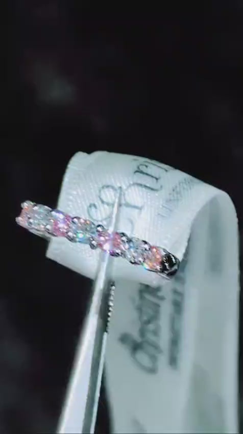 Platinum seven-stone ring sparkling under light, showing pink and white lab diamonds