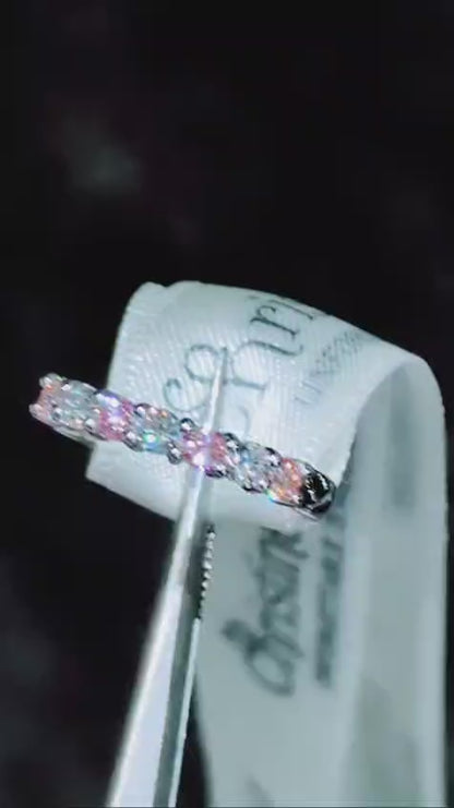 Platinum seven-stone ring sparkling under light, showing pink and white lab diamonds