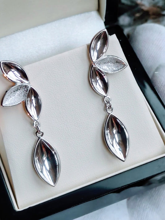 modern silver statement earrings with almond shaped details that look like seed pods. For each pair of these earrings purchased a tree is planted. 