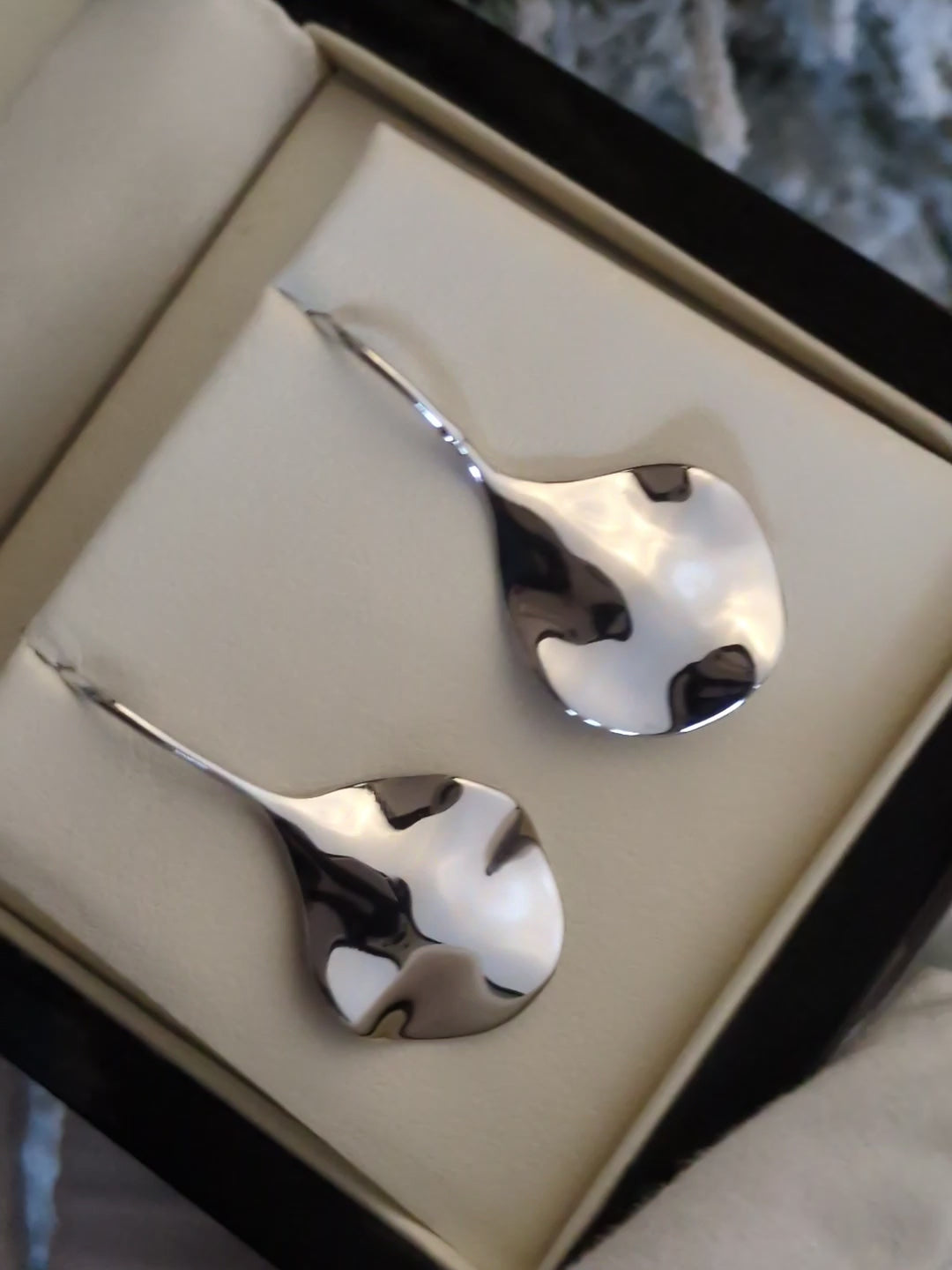 modern silver designer earrings that ripple like water by jewellery designer Jorge Revilla