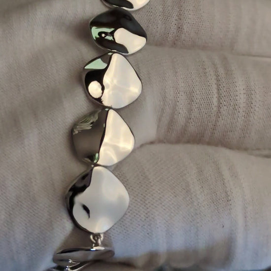 reflective highly polished silver bracelet that has lots of square links with rounded corners