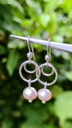 a pair of sterling silver circle drop earrings with a pale pink cultured pearl from Christine Sadler