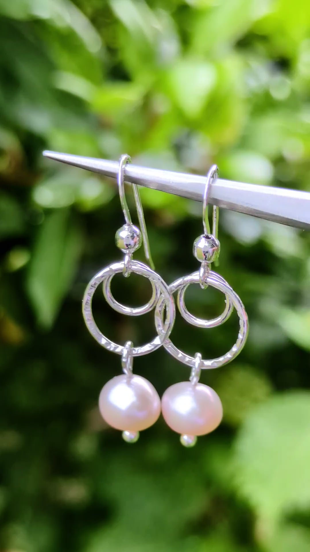 a pair of sterling silver circle drop earrings with a pale pink cultured pearl from Christine Sadler