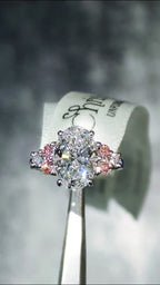 Rosé Spark platinum 950 oval lab diamond ring moving to reveal maximum sparkle from the central 3ct white lab diamond and six side stones with pink accents.