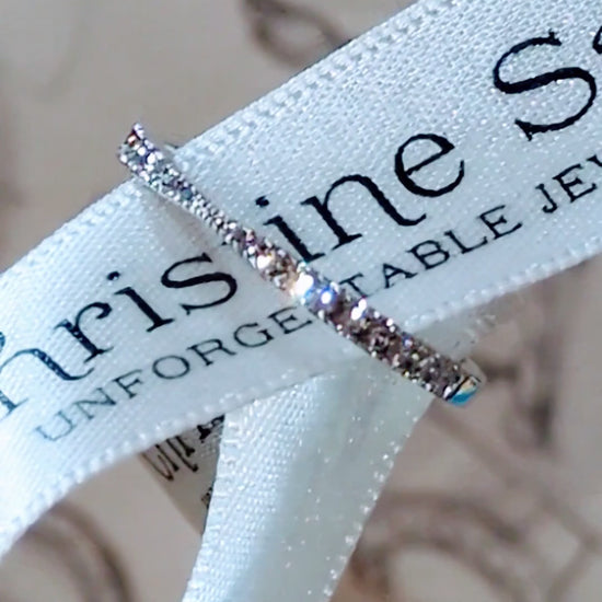 narrow diamond wedding ring for a woman in platinum with a pinched middle