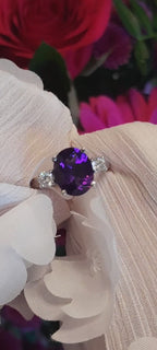 Video showing the intense deep purple colour and sparkle of this high quality amethyst and diamond three stone platinum ring