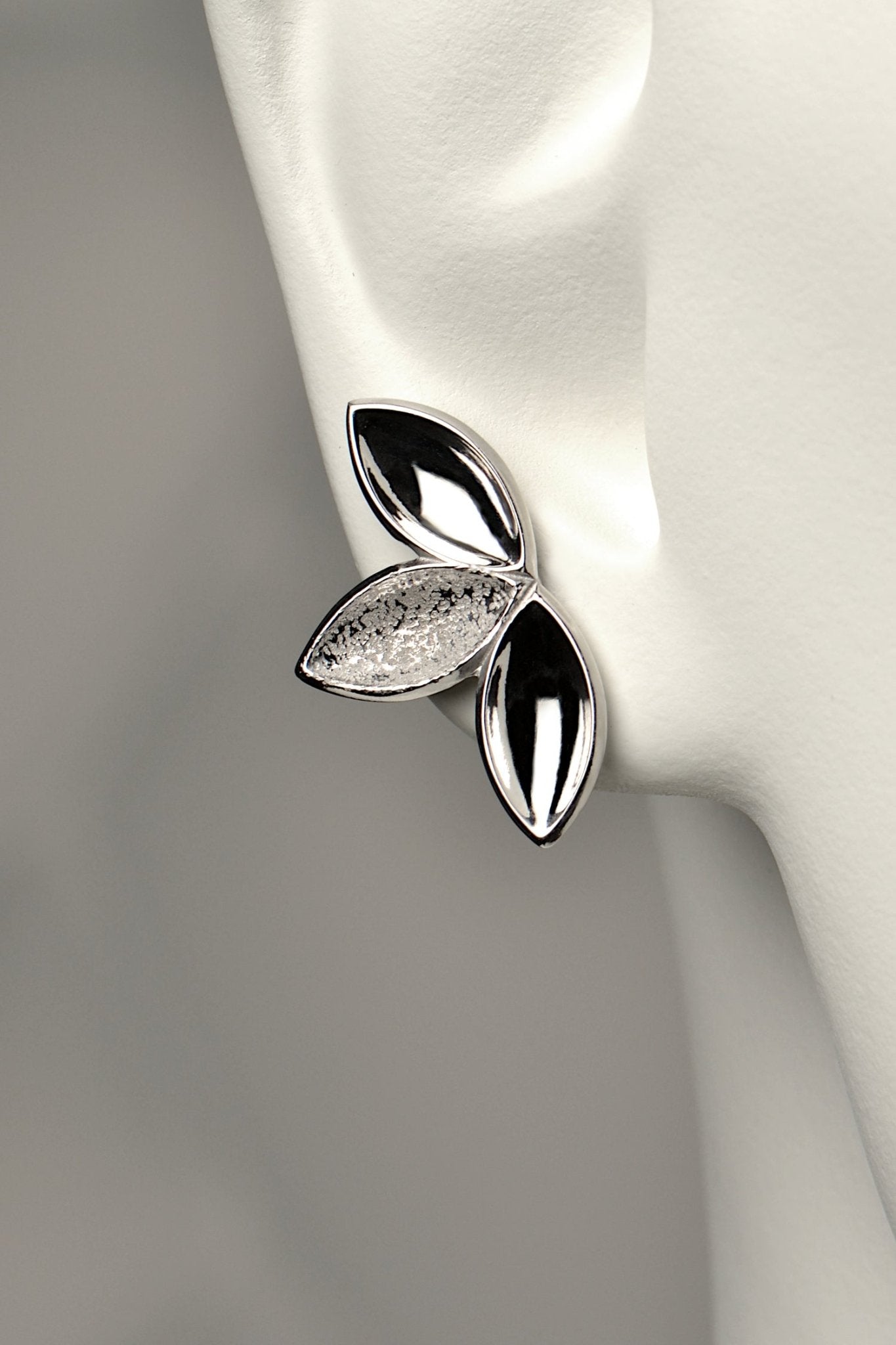 fairy like large silver stud earring made of three concave seed pod shapes in highly polished and contrasting modern textured finishes. The Promise jewellery collection from Christine Sadler plants a tree for every piece sold.