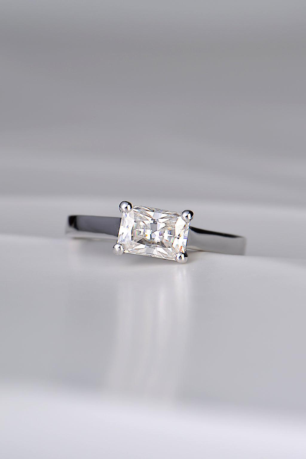 contemporary designer engagement ring handmade in the UK. Rectangular gemstone sitting across the ring in a white gold band.