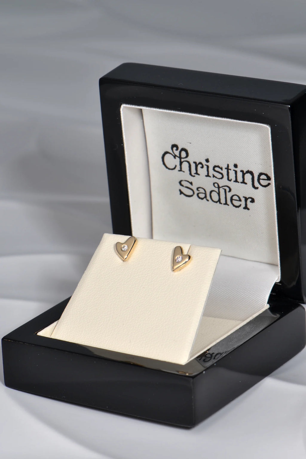 9ct yellow gold heart stud earrings with flush-set diamonds in a black lacquer presentation box