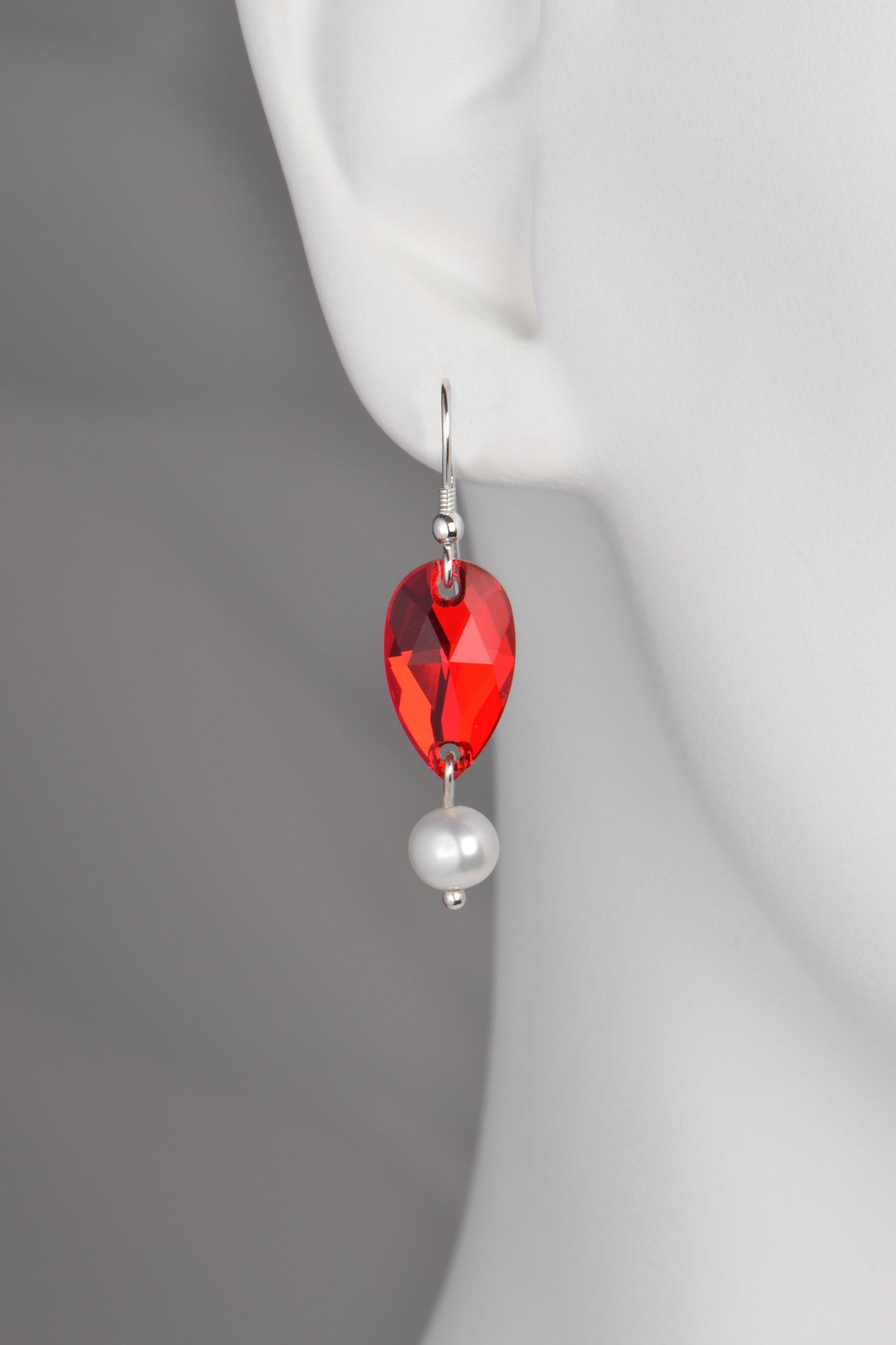 sterling silver hook earrings with a red teardrop shaped austrian crystal and a single round cultured pearl below it in a hot air balloon shape