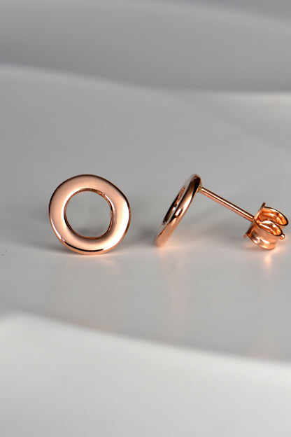 rose gold circle earrings shown side on so you can see that they are flat and sit close to the earlobe