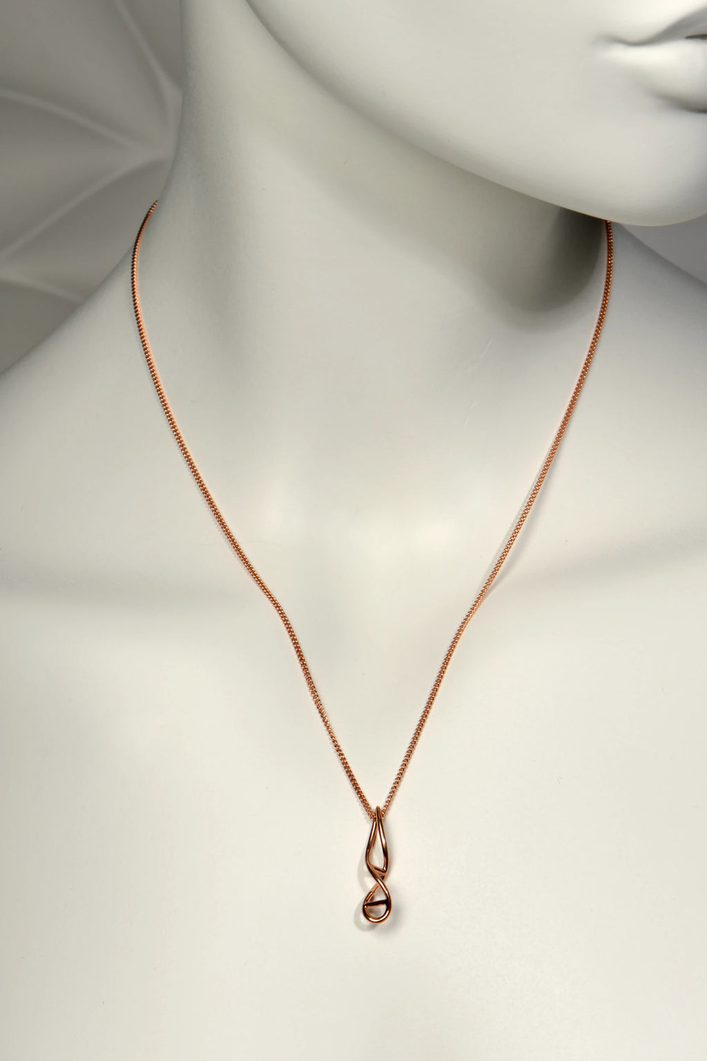 9ct rose gold elegant necklace in a double helix shape on a mannequin with a plain background from jewellery designer Christine Sadler
