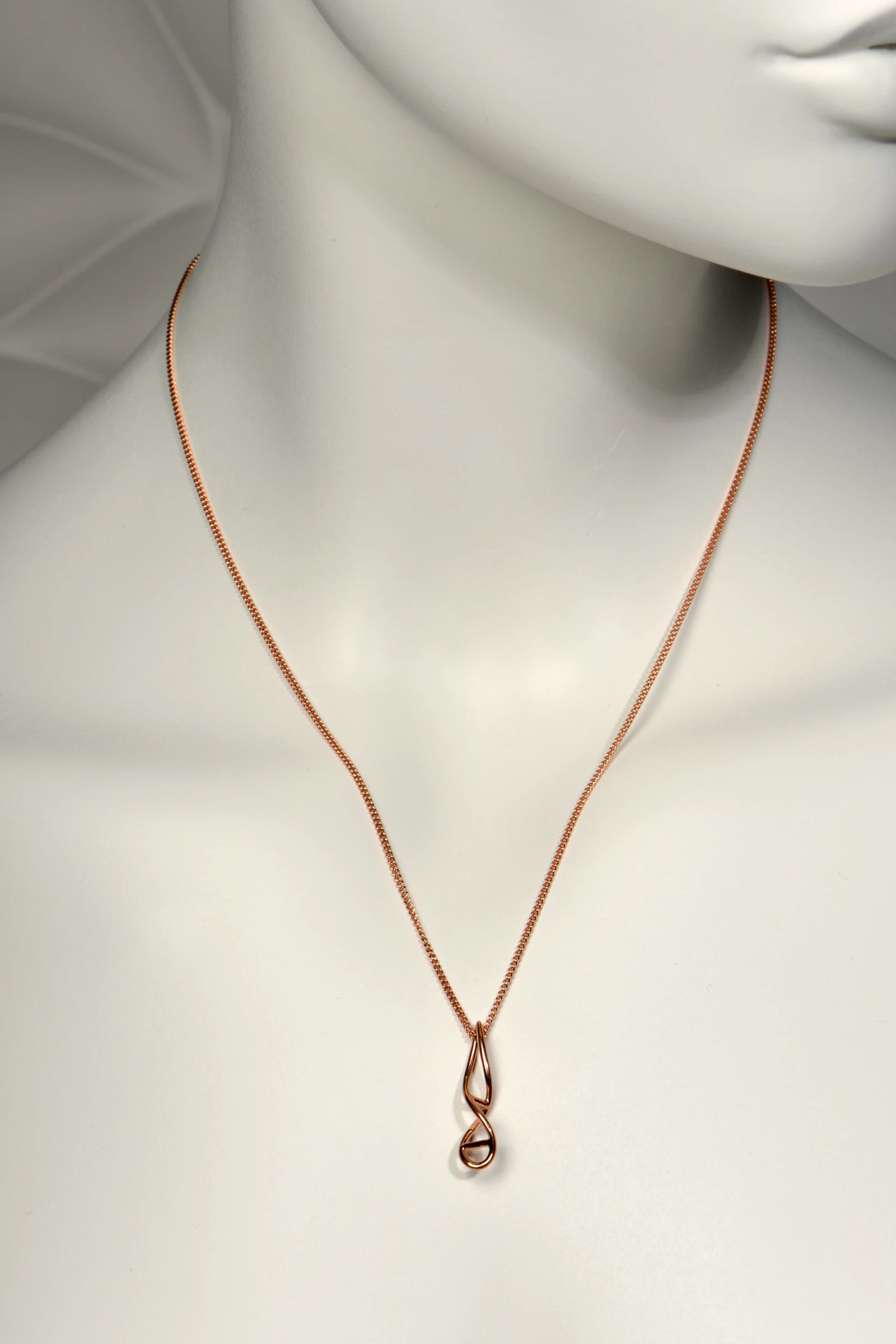 9ct rose gold elegant necklace in a double helix shape on a mannequin with a plain background from jewellery designer Christine Sadler