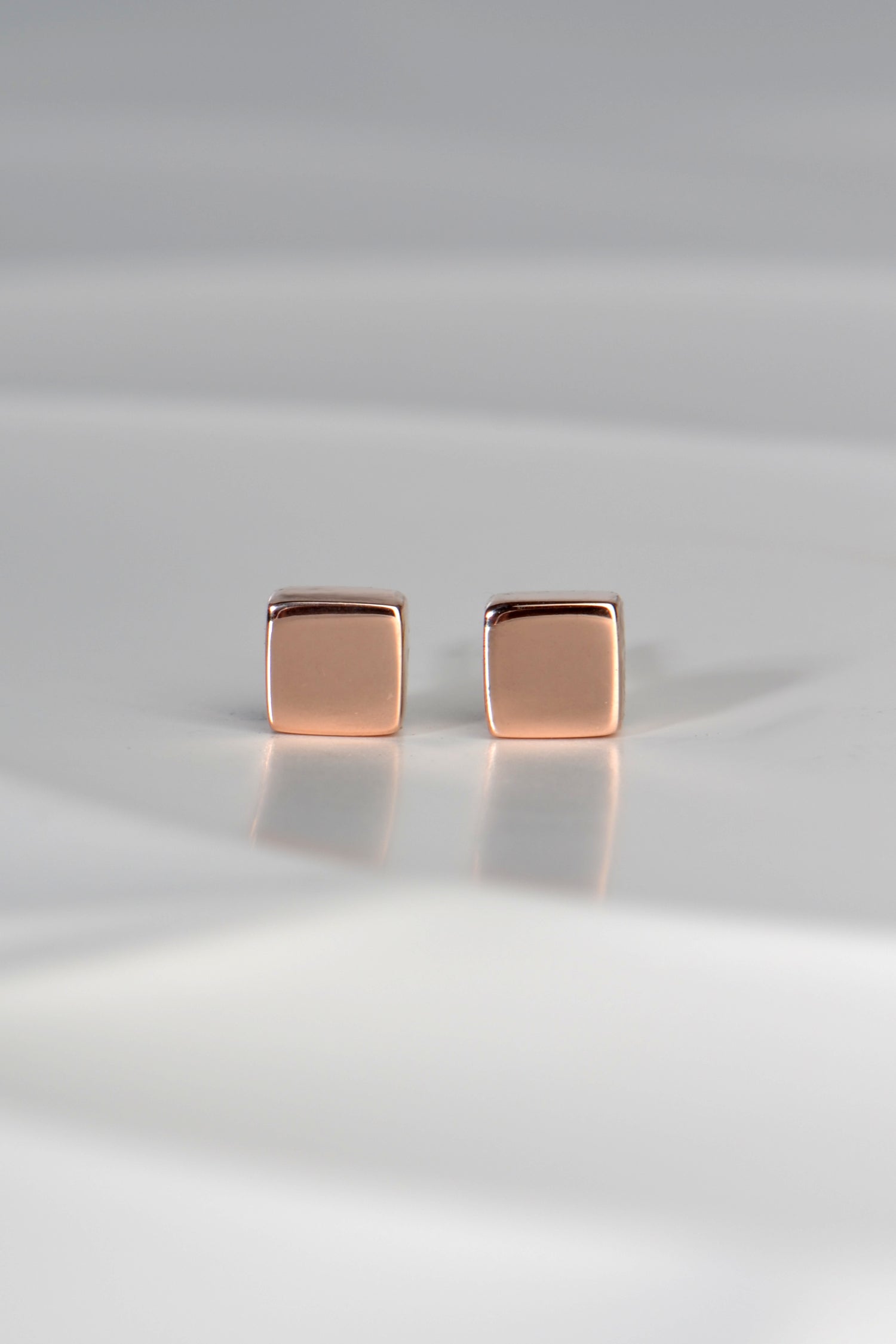 designer earrings made of polished small square blocks of gold
