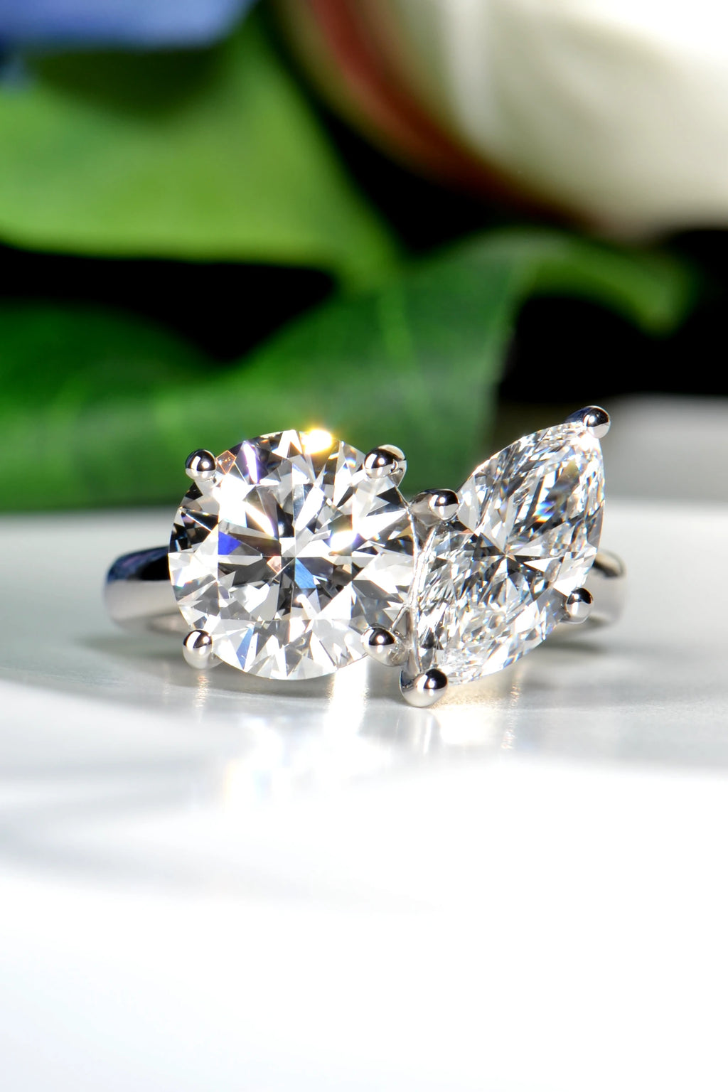 Hand crafted Platinum 950 Toi et Moi ring featuring a round brilliant and marquise lab-grown diamond set against a natural background of green leaves and flowers from Christine Sadler